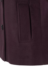 Bordeaux wollen jas met een gladde textuur, zijzak en zwarte knopen. De stof heeft een zachte afwerking, wat de warmte en het comfort vergroot.