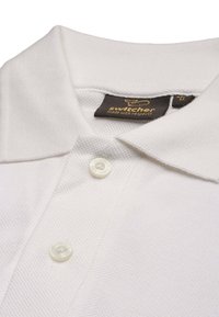 Polo bianco realizzato in tessuto testurizzato, con patta a tre bottoni e colletto. L'etichetta riporta "switcher" con le istruzioni per la cura.