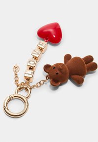 Schlüsselanhänger mit einer braunen Teddybärfigur, einem glänzenden roten Herzanhänger und goldenen Beschlägen mit kubischen Akzenten sowie einem runden Befestigungsring.