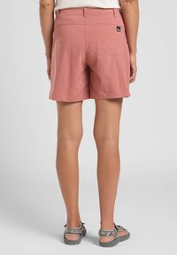 Pantaloni corti leggeri rosa con vita strutturata e tasche posteriori. Il tessuto sembra liscio e leggermente texturizzato.