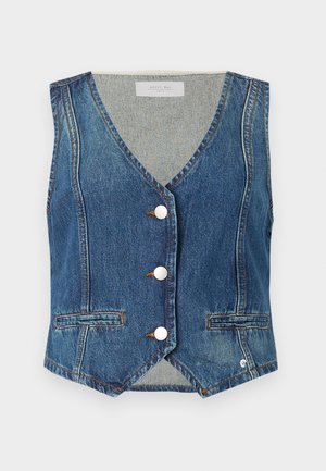 Denim veste vidēji zilā krāsā ar V-veida kakla izgriezumu, sudraba pogu priekšpusi un divām atvērtām kabatām. Iezīmē kontrastējošie vīlējumi un nedaudz īsāku apakšmali.