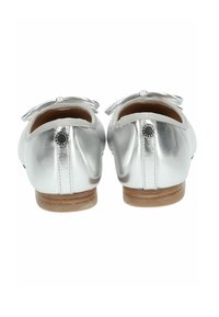 Ballerines en cuir argenté avec un détail en nœud à l'arrière, semelle en caoutchouc marron, texture lisse et accent décoratif rond près du talon.