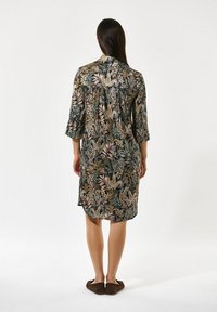 Kleid mit Knopfleiste, das ein mehrfarbiges botanisches Muster auf dunklem Hintergrund zeigt, 3/4-Ärmel und eine lockere Passform mit abgerundetem Saum.