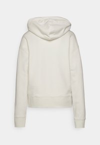 Felpa crema con cappuccio, spalle basse e polsini a costine. Texture morbida e lunghezza cropped con un design semplice.