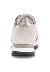 Lage sneaker van lichtbeige suède met een metalen accent bij de hiel, voorzien van een zwarte rubberen zool en een slank design.
