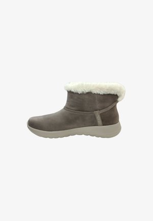 Braune Wildleder-Stiefelette mit einem weißen Kunstpelzkragen, abgerundeter Spitze und einer strukturierten Gummisohle für besseren Grip. Sichtbare seitliche Nahtdetails.