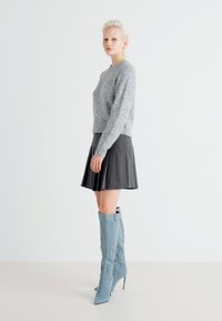 Gray wool sweater, black pleated skirt, tall blue stiletto boots, smooth textures, with a clean, minimalistic background.