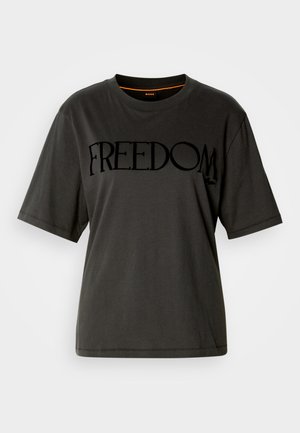T-shirt di cotone nero, vestibilità oversize, scollatura rotonda, con la scritta in bold "FREEDOM" stampata sul davanti in finitura opaca. Maniche corte.
