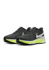 Zapatillas deportivas negras con parte superior de malla texturizada, puntera reforzada, distintivo swoosh blanco de Nike y una entresuela verde vibrante, que cuenta con un cuello acolchado.