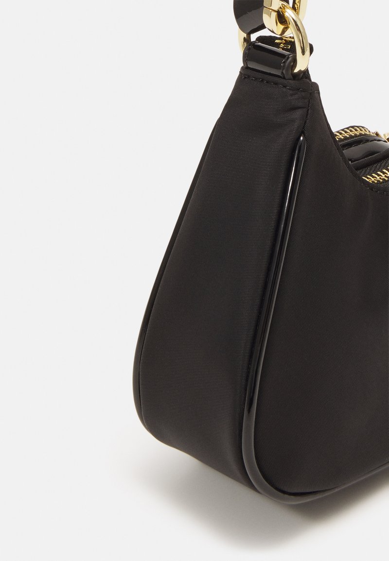 Schwarze Stoffhandtasche mit glatter Textur, ausgestattet mit glänzendem schwarzen Reißverschlussbesatz und goldenen Hardwareakzenten. Gebogene Form und Reißverschlussverschluss.