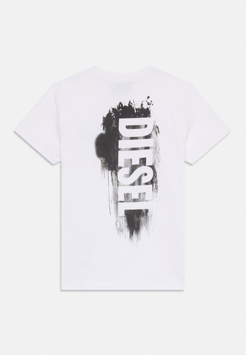 T-shirt di cotone bianca con un design a macchie di vernice nera e la parola "DIESEL" stampata verticalmente sulla schiena in lettere grandi.