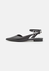 Zapato plano de cuero negro tipo slingback con punta afilada, tira de tobillo con hebilla ajustable y diseño minimalista.