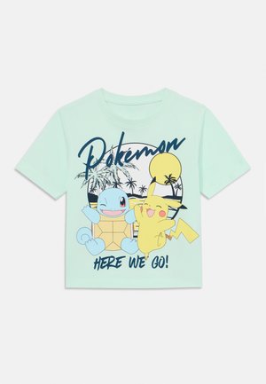 Mere roheline T-särk, millel on multikategelased Squirtle ja Pikachu, ning tekst "Pokémon" ja "HERE WE GO!" rasvases navy sinises kirjas.