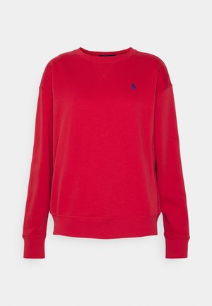 Rode longsleeve trui met ronde hals, geribde manchetten en zoom, met een klein blauw geborduurd logo op de linkerborst.