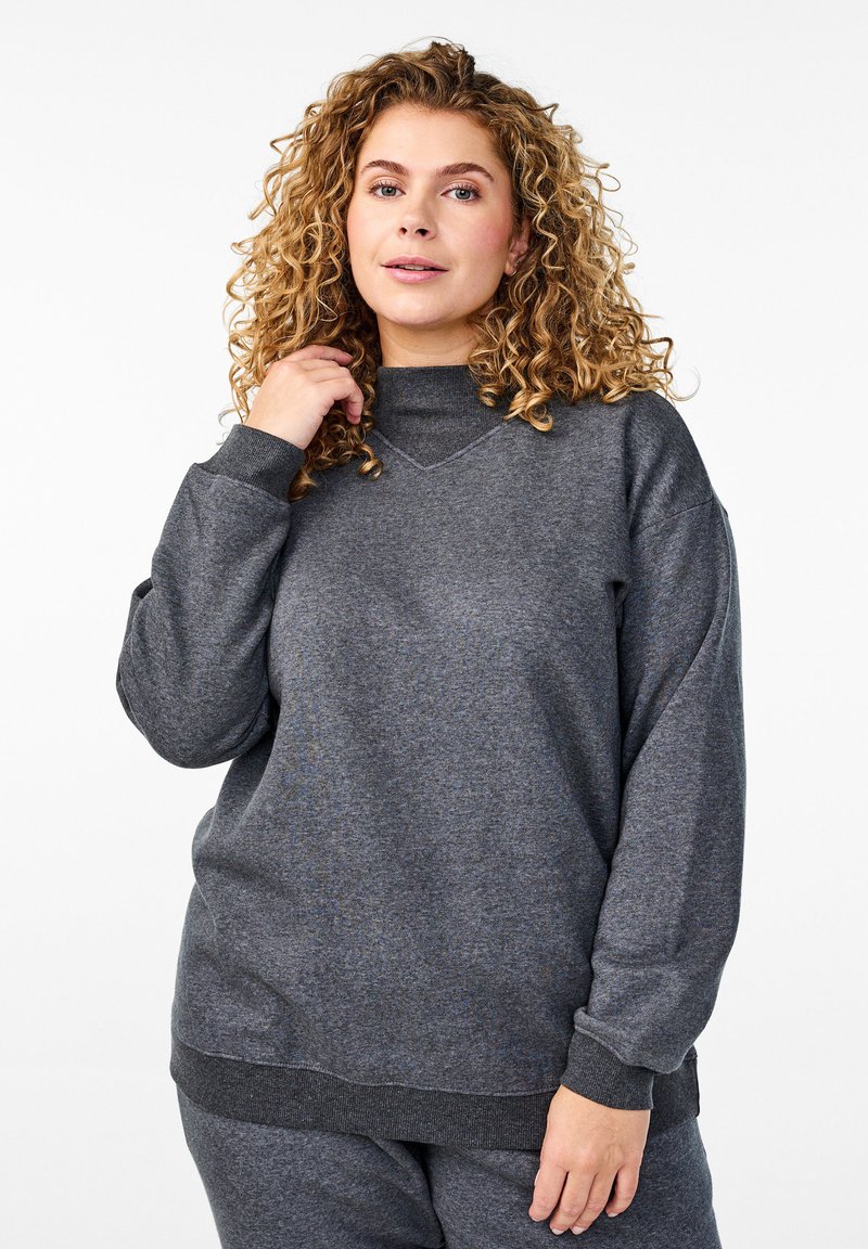 Felpa grigia con un collo alto, maniche lunghe, polsini a costine e un tessuto testurizzato. Presenta una vestibilità comoda e un design minimalista.
