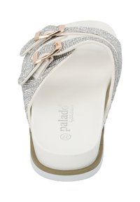 Silverprydda sandaler med två dekorativa spännen, med en vit bas och texturerade remmar för grepp och komfort.