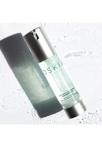 Gel detergente trasparente in una bottiglia cilindrica con pompe argento. Presenta una sfumatura verdognola e testo in nero sull'etichetta frontale.