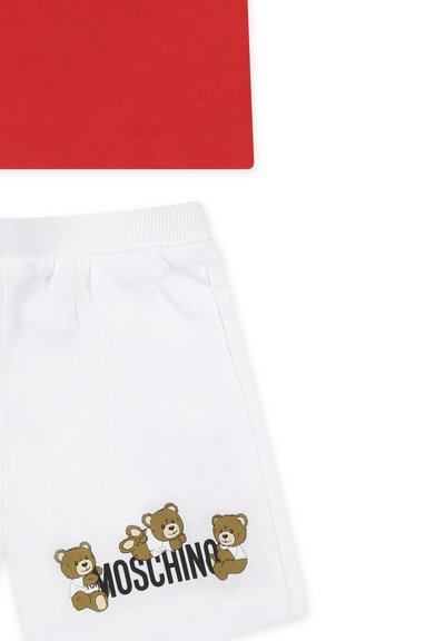 T-shirt rossa in cotone sopra pantaloni corti bianchi in cotone con tre grafiche di orsi bruni e testo "Moschino", vita elasticizzata sui pantaloni.