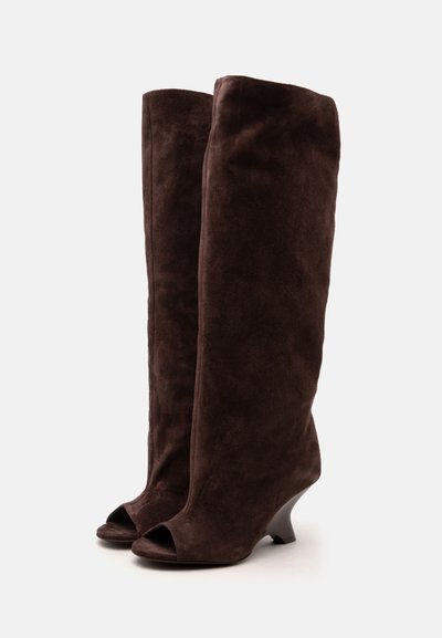 Paire de bottes hautes en daim brun foncé, à bouts ouverts et talons côniques courts, sur fond blanc uni.