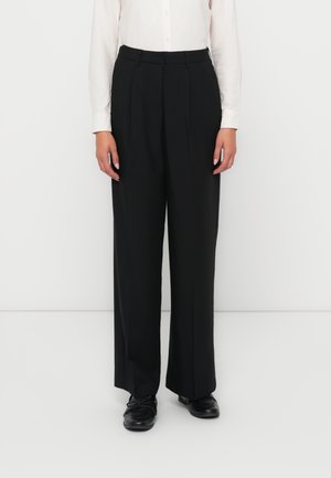 Black wide-leg trousers made from a smooth fabric, featuring a pleated design, with a high waist and subtle front creases.