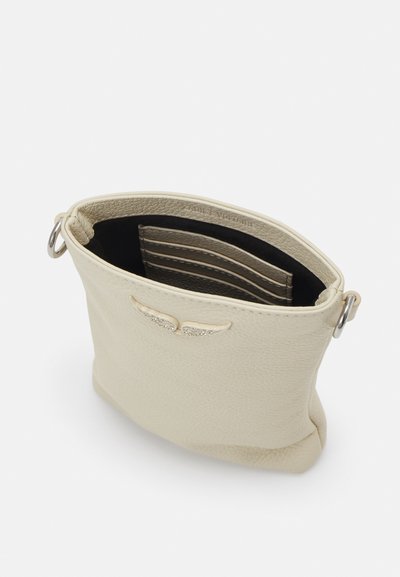 Beige bőr tárca struktúrált felülettel, ezüst szárny díszítéssel és fekete belső térrel, amely kártyahelyeket és minimalist design-t tartalmaz.