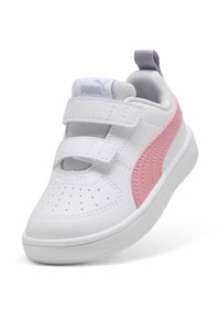 Baskets synthétiques blanches avec des accents roses, bout perforé et double bande Velcro. Semelle légère avec logo PUMA sur le talon et la languette.