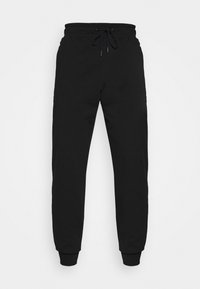 Schwarze Jogginghosen mit elastischem Bund und Kordelzug, tapered Beine und gerippten Bündchen, vor weißem Hintergrund präsentiert.