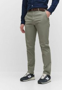 Ljus olivgröna byxor med skräddarsydd passform, med sidofickor och en slät textur. Stylar dem med mörka sneakers och en marinblå skjorta.