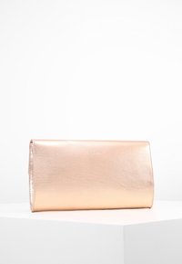 Obdélníková metalická růžově zlatá kabelka s hladkým povrchem, umístěná na bílém podstavci proti jednoduchému bílému pozadí.