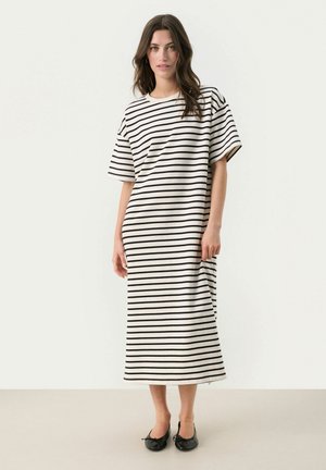 Robe maxi rayée en blanc et noir. Caractéristiques : manches courtes, coupe décontractée et silhouette droite avec une longueur arrivant mi-mollet.