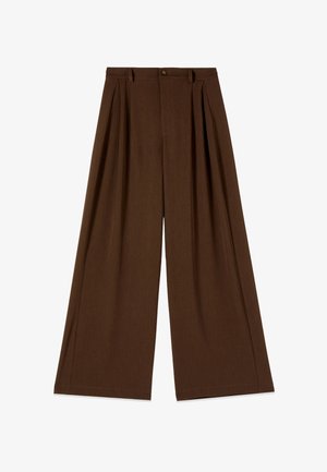 Korkeavyötäröiset, leveälahkeiset ruskeat housut, joissa on laskokset, vyölenkit ja napillinen suljenta etuvyötäröllä.