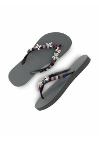 Zwarte flip-flops met een verhoogde, gestructureerde zool en een decoratieve band met kleurrijke kralen en bloemaccenten, geplaatst op een witte achtergrond.