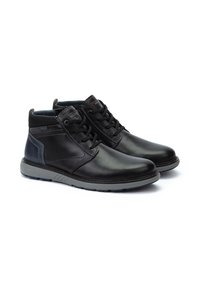 Botas de tobillo de cuero negro con suelas de goma gris, diseño con cordones y acentos laterales texturizados. Presenta un tacón gris reforzado.