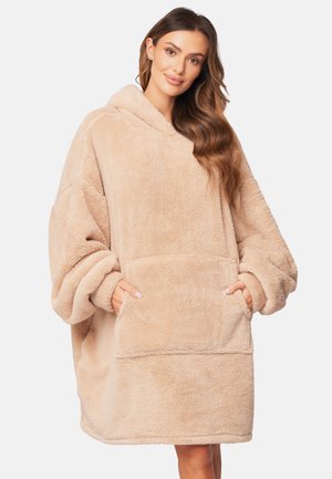 Felpa beige oversize realizzata in tessuto morbido e peloso, dotata di una grande tasca frontale e cappuccio. Texture morbida con maniche larghe.