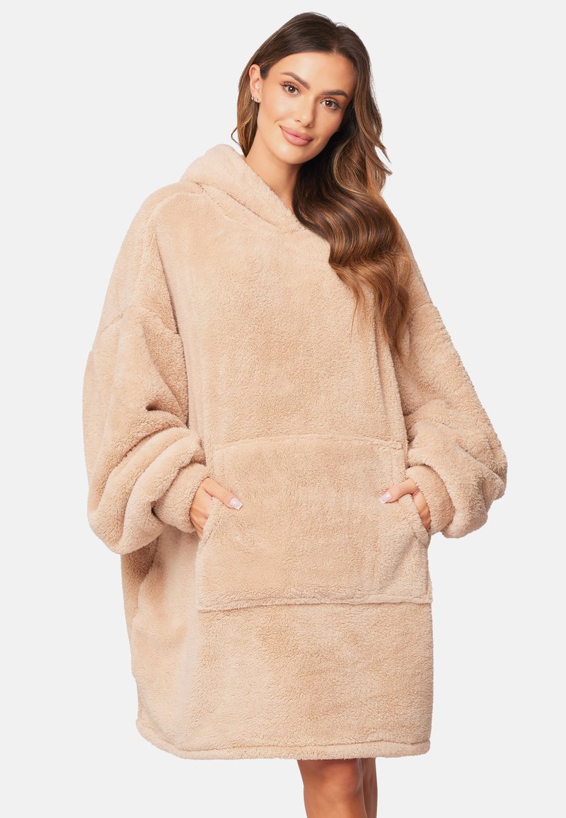 Oversized beige hoodie gemaakt van pluizige, zachte stof met een grote voorkantzak en capuchon. Zachte textuur met wijde mouwen.