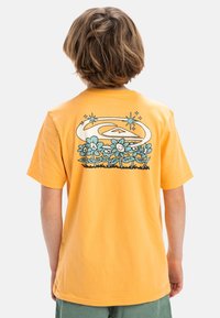 Camiseta de algodón naranja de manga corta con un gráfico floral colorido y un diseño espiral en la parte posterior, de corte relajado y cuello redondo.