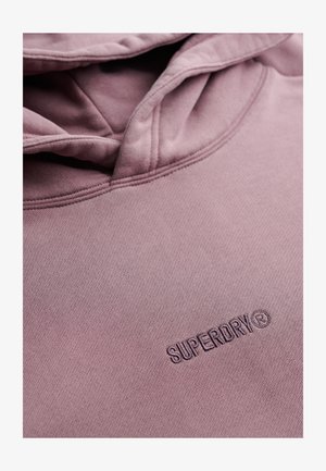 Sudadera con capucha rosa hecha de tela suave con una superficie texturizada; presenta un logo "SUPERDRY" cosido en el frente. Diseño clásico con capucha.
