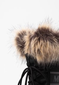 Zwarte winterlaars met nepbont in beige en bruin aan de bovenkant, met een gestructureerd stoffen oppervlak en een veterontwerp aan de voorkant.