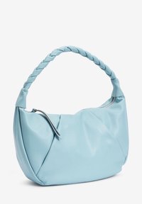 Sac à main en cuir bleu clair avec une poignée tressée, un corps souple et structuré, et une fermeture éclair avec un tirette en cuir.