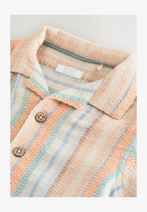 Rövid ujjú, szőtt ing, texturált mintával. Narancssárga, kék és krémszínű csíkokkal rendelkezik, fából készült gombokkal a gombolásnál.