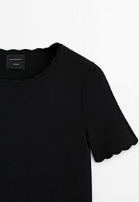 Haut noir en maille côtelée à manches courtes avec bords festonnés aux manches et à l'encolure, étiqueté Massimo Dutti Studio.