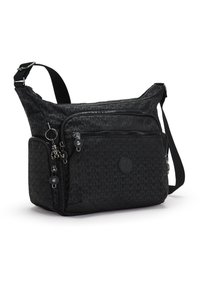 Black fabric crossbody bag features a geometric pattern, multiple zippered compartments, a decorative charm, and an adjustable strap.