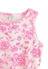 Ribbet ærmeløs top i creme med pink blomster mønster. Har en rund halsudskæring og subtil tekstur. Etiket synlig indeni.