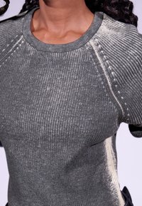 Grauer, gerippter Pullover mit Rundhalsausschnitt, kontrastierenden, hellen Nähten und strukturiertem Stoff in taillierter Form.