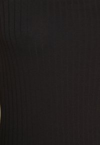 Tessuto nero a coste con texture verticale; superficie liscia con un leggero lucido; materiale elastico e aderente. Nessun motivo o accento.