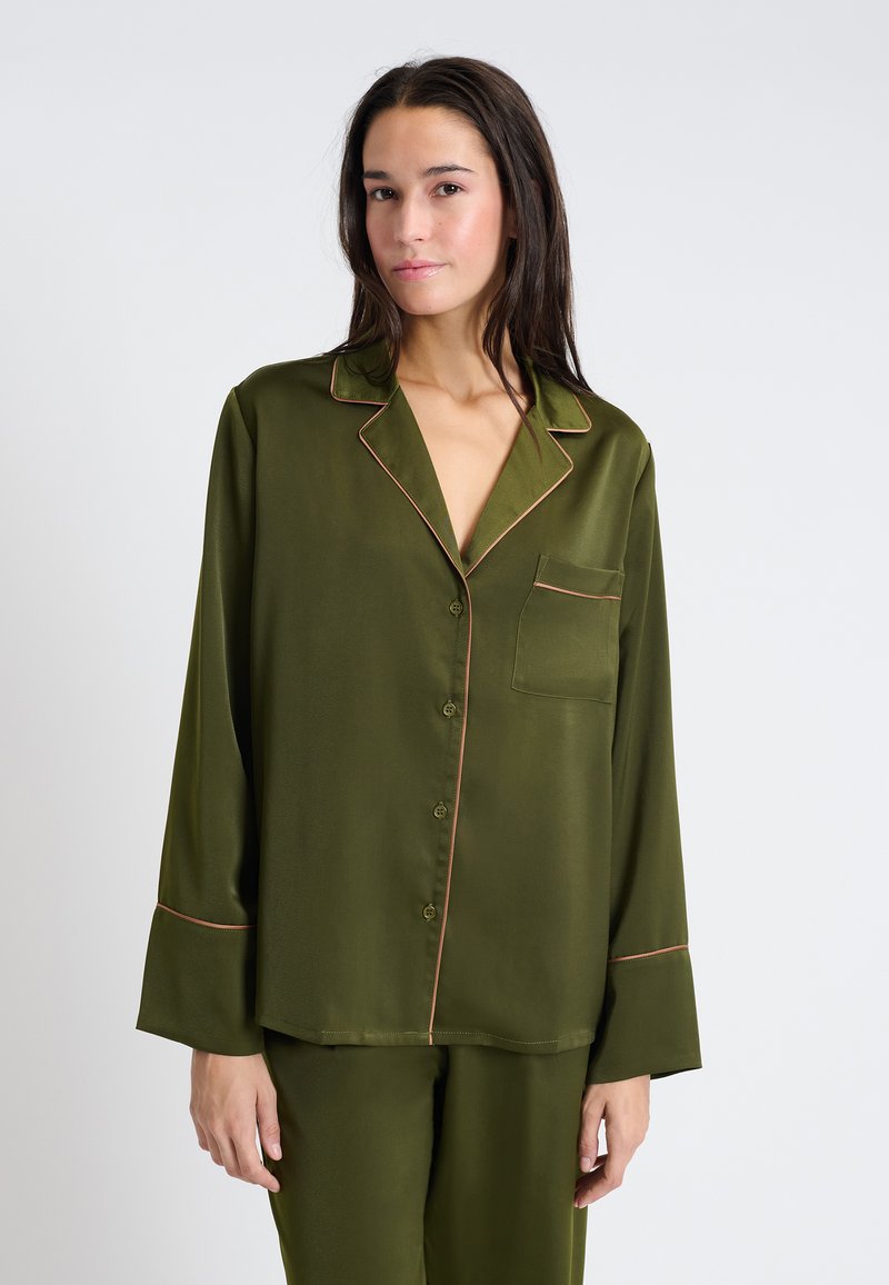 Satinowa oliwkowa bluzka od piżamy z kołnierzykiem, długimi rękawami, zapięciem na guziki z przodu oraz kontrastowym jasnoróżowym wykończeniem wzdłuż brzegów i kieszeni.