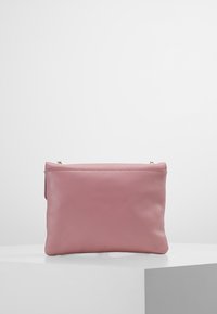 Różowa kopertówka ze skóry o gładkiej fakturze, prostokątnym kształcie i zamknięciu na zamek. Charakteryzuje się minimalistycznym designem bez widocznych elementów metalowych.