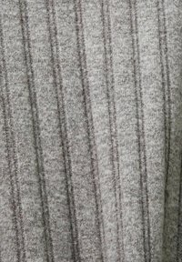 Harmaa neulottu kangas, jossa on pystysuora nauhakuvio, esittäen vaihtelevaa harmaan sävyä ja pehmeää, hieman karheaa pintaa.