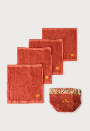 Quatre carrés lavables de couleur rouille et une pochette assortie couleur rouille avec un bord en tissu à motif, tous brodés d'un logo jaune.