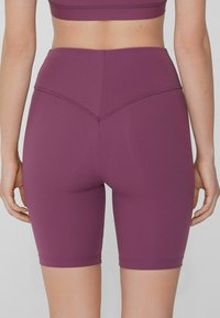 Shorts da bici alti in vita, di colore viola, realizzati in materiale elasticizzato. Presentano un design senza cuciture con un dettaglio di cucitura curva sul retro.